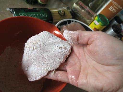 chicken dipped on flour mixture in orange bowl