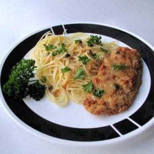 Chicken Picatta served over warm angel hair pasta and topped with fresh parsley