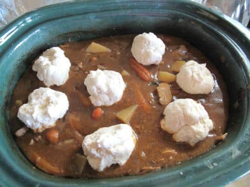 Dumpling batters on the top of stew/soup concoction in the crockpot