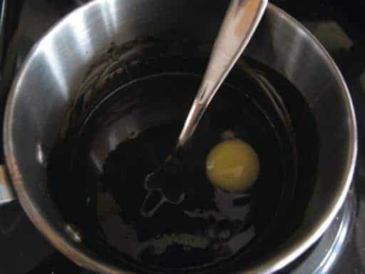 beating the egg in melted butter/cocoa mix in a large pot