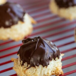 close up Chocolate Dipped Coconut Macaroons on red cooling rack