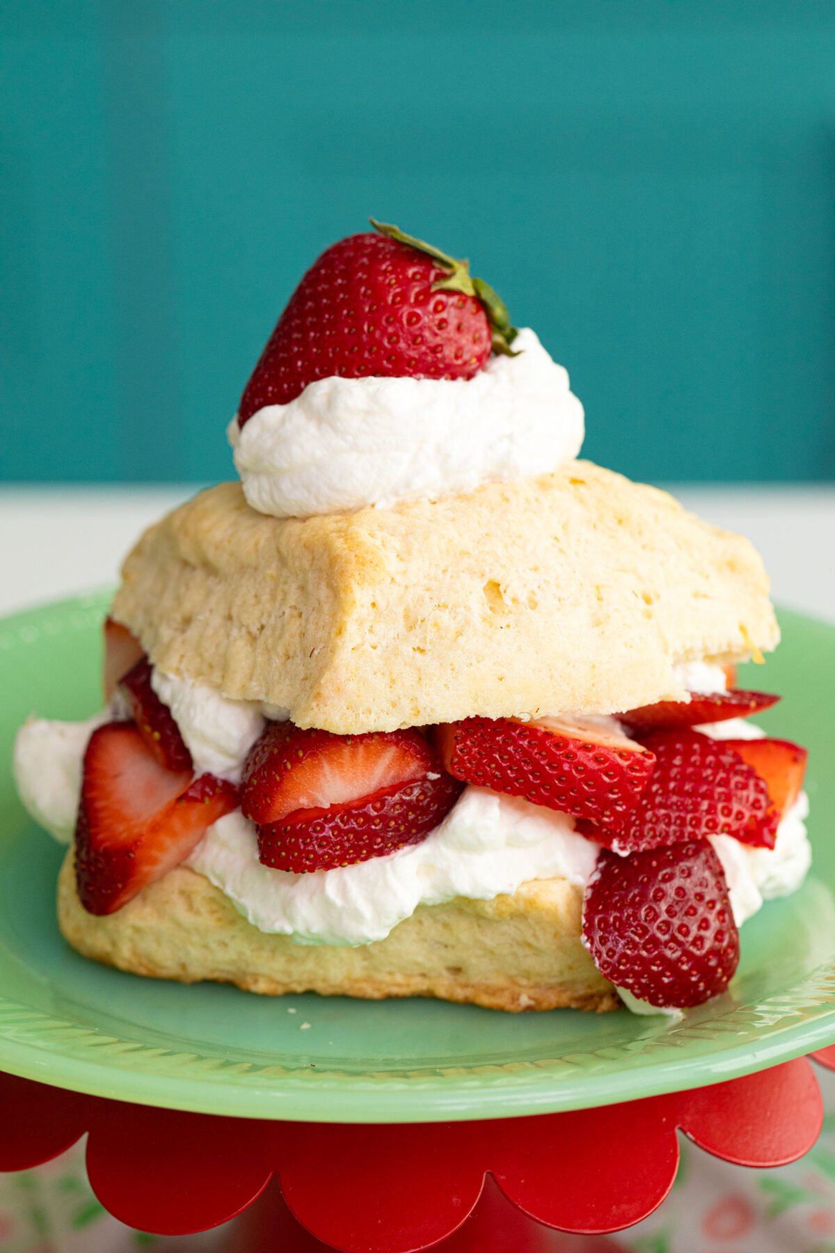 Lemon Strawberry Shortcake on a green plate closeup of the strawberries coming out of the scone