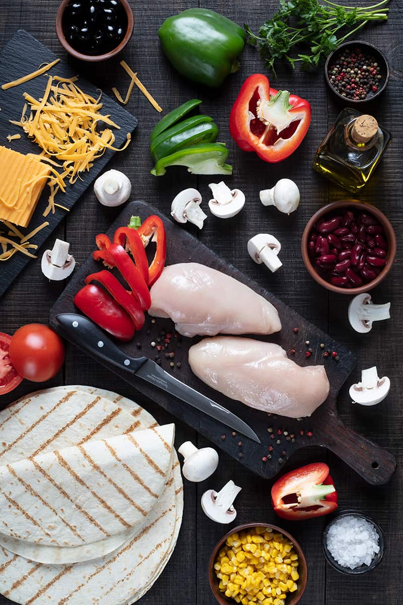 quesadilla ingredients in wooden cutting boards on a dark wood background