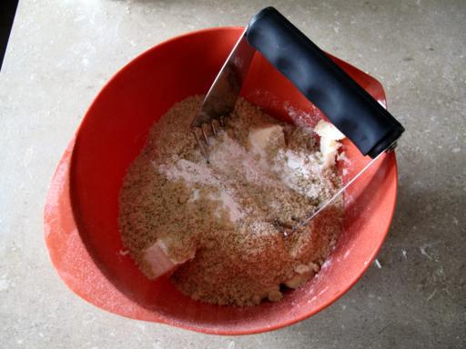 Red bowl with sugar, flour and butter being cut