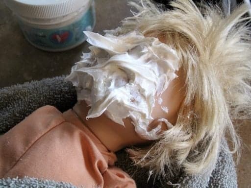 a doll with cream on the face
