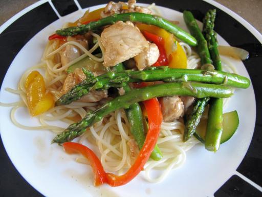 Close up of A Plate with Chicken Asparagus Stir Fry Over Angel Hair Pasta