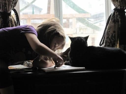 little girl creating a portrait of her beloved cat