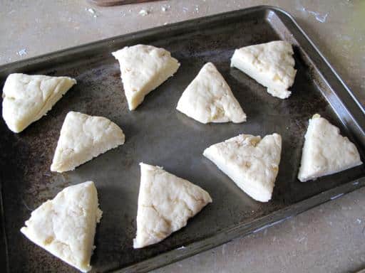 triangular cut dough place on a well greased baking sheet ready for baking