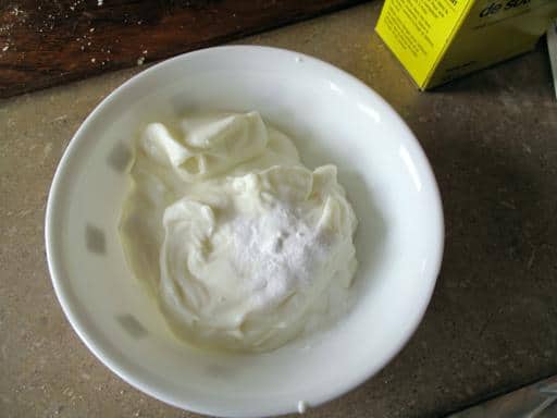 Mixture of sour cream and baking soda in a white small bowl