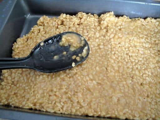 Stirring in the cereals to the melted ingredients
