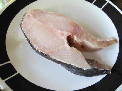 a piece of raw halibut steak in a plate