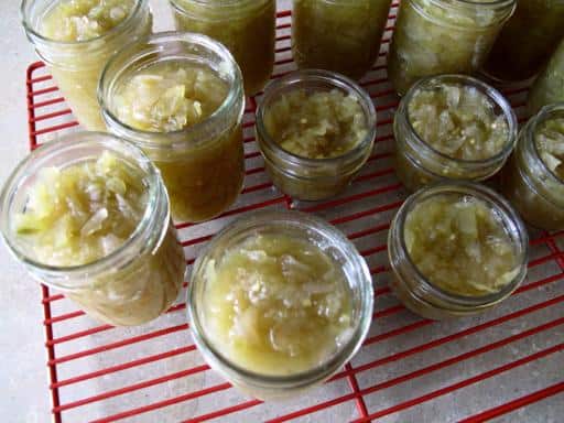 Green Tomato Relish in sterilized jars over red wire rack