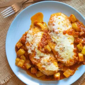 Steak Knife and fork beside a plate of Chicken Parmigiana