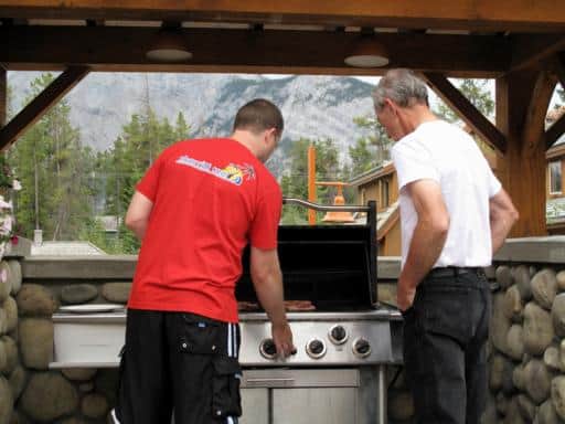 two men on the barbeque to cook some delicious rib eye steaks