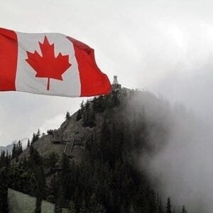 close up waving Canadian flag with the view of mountain