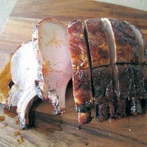 slices of Spicy Roast Pork in wooden board