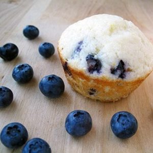 piece of Lemon Blueberry Muffin and some fresh blueberries around it