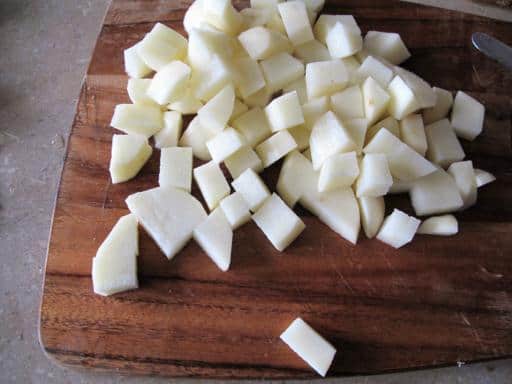 Peeled and chopped potatoes in wood board for Pasulj