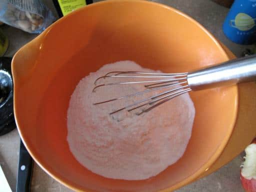 Whisking together the flour and baking powder in an orange bowl