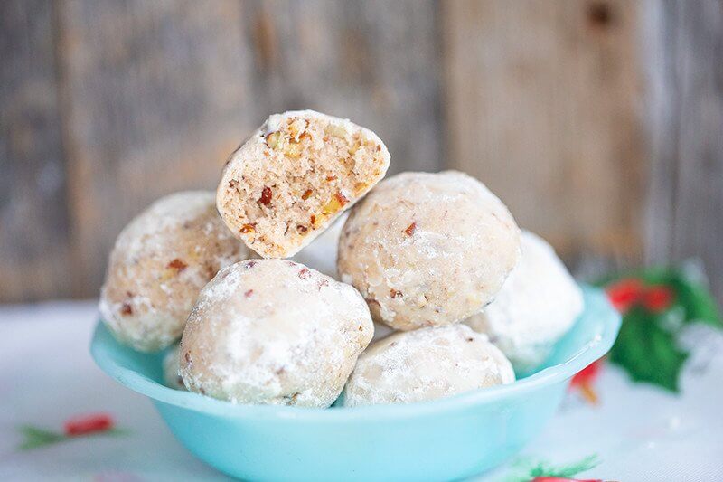 Russian Tea Cakes or Snowball Cookies in a jade blue bowl
