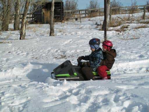christmaseve8_512x384 young siblings riding a single Ski-Doo