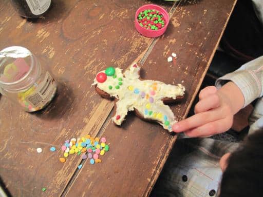 adding decoration to a gingerbread man cookie