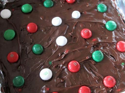 green, red and white M&M on top of chocolate icing