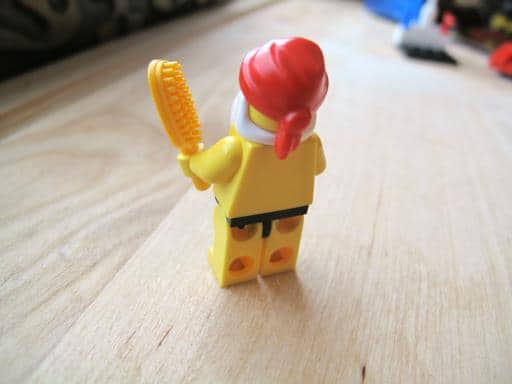 yellow Santa holding a yellow hair brush lego