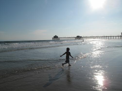 young boy running in the ocean