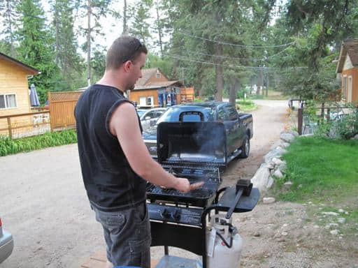 man wearing black sleeveless shirt using the barbeque