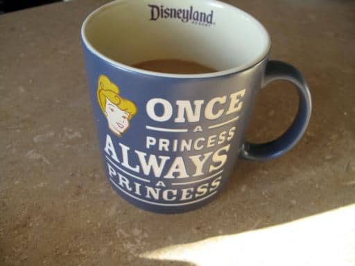 a cup of coffee in a blue Disneyland mug