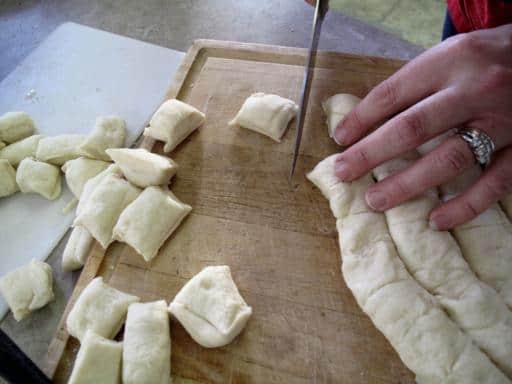 Homemade Monkey Bread dough in wooden board being cut into squares