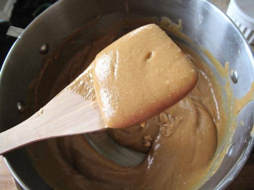 Melted ingredients of Honey Bars in a large pot with wooded spatula