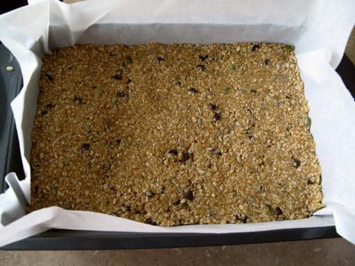 Pressed mixture of Honey Bars in the pan with parchment paper
