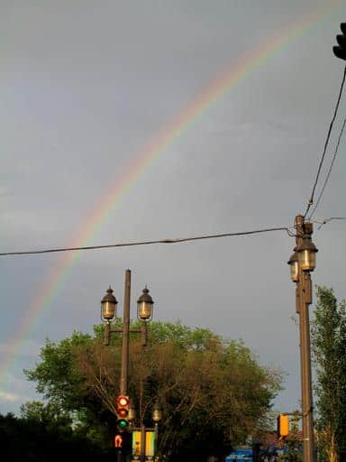 a rainbow in the sky, with the view of street lights