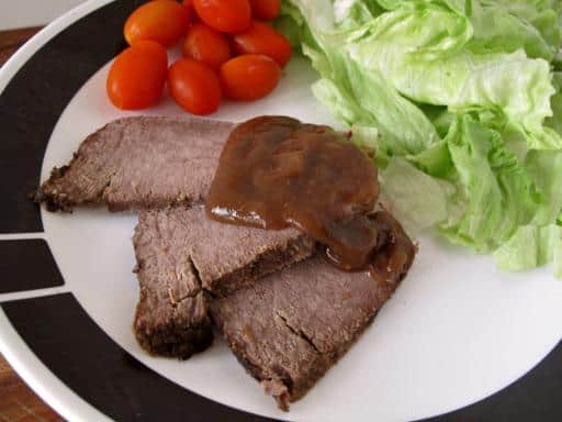 slices of pot roast with creamy gravy, sided with vegetables