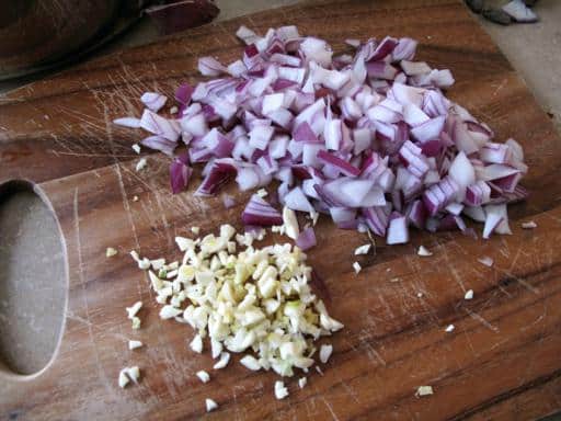 chopped onion and garlic on wood board