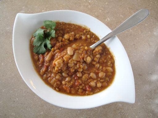 Spicy Bean & Lentil Soup in a White Bowl with Spoon in it
