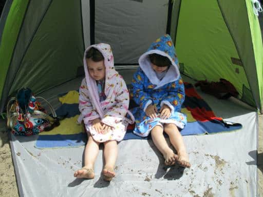 kids wearing their robes sitting inside the beach tent