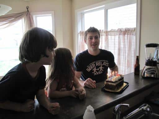 man and the two kids with cake in front of them 