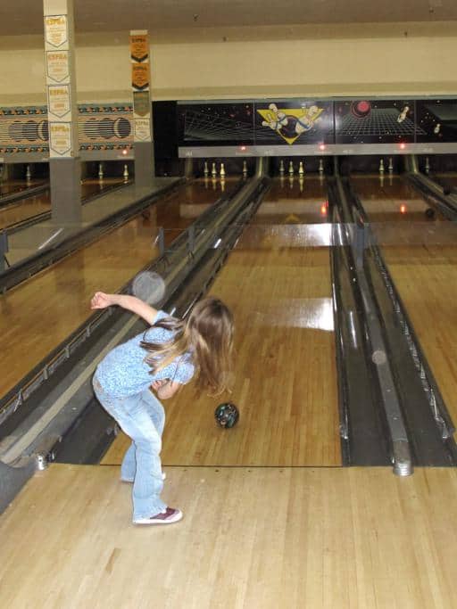 little girl playing bowling
