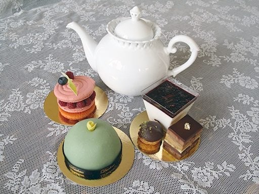 cakes and pastry with the white tea pot on top of the table