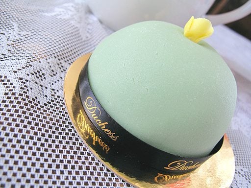 cake topped with a dome of vanilla bean whipped cream and encased in a naturally colored marzipan shell