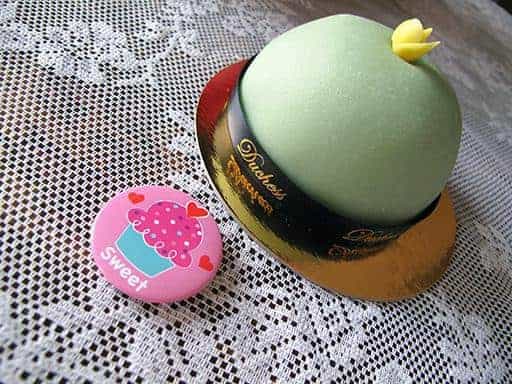 pink button and little green cake on top of table