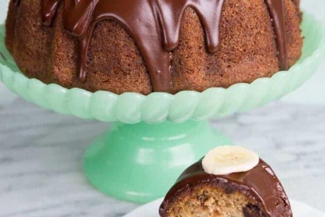 Chocolate Banana Buttermilk Bundt Cake in a jade green cake holder and a slice in a white plate with fork