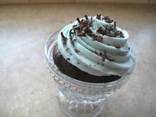 chocolate cupcake in a glass topped with mint icing and shredded chocolates