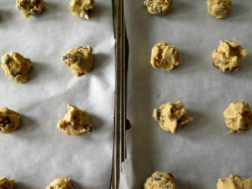 teaspoonful chocolate chip cookie dough in parchment lined cookie sheets