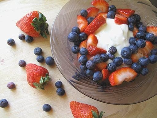 Greek Yogurt & Fresh Berries in a large bowl, some Fresh Berries out side the bowl