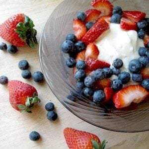 Greek Yogurt & Fresh Berries in a large bowl, some Fresh Berries out side the bowl