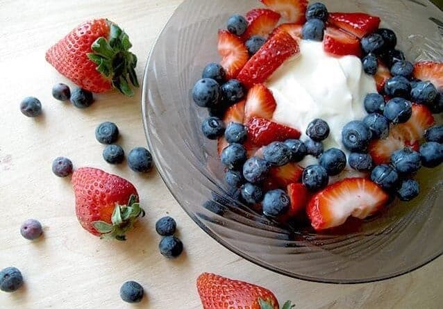 Greek Yogurt & Fresh Berries in a large bowl, some Fresh Berries out side the bowl
